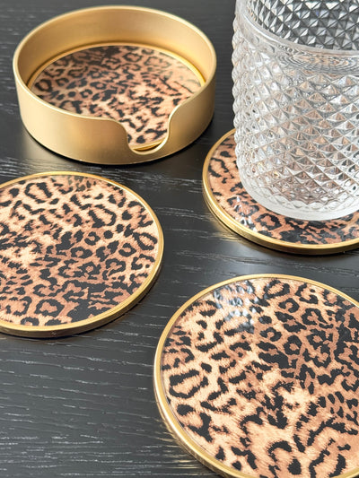 Add a rock ‘n’ roll edge to your table settings with the Set of 4 Leopard Print Coasters. Bold and stylish, this set of glass coasters boasts a glamorous leopard print design, accented by a chic gold rim and accompanied by a stunning gold coaster holder. A fashionable way to introduce color, pattern, and personality to your tablescapes, these round coasters not only safeguard your surfaces from ring marks but also enhance your decor with a touch of exotic flair.